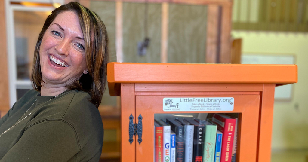 woman leaning against a cabinet filled with books